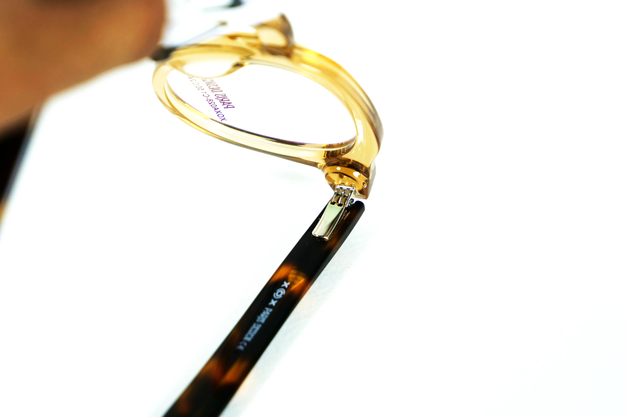 Detalle real del sistema de doble bisagra Flex de la montura XOXA028